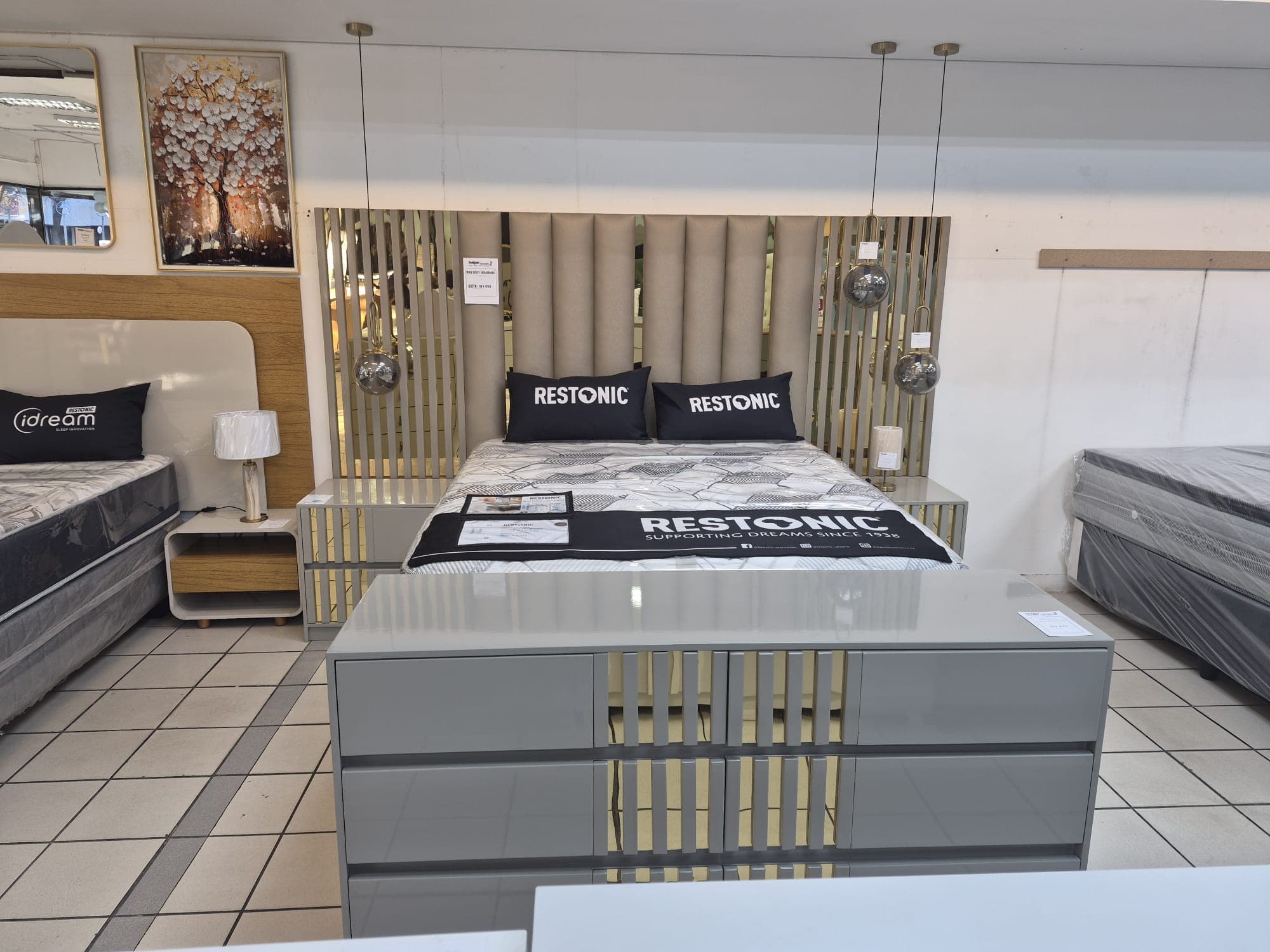 Grey lacquer bed with gold mirror-stripe headboard styled in a finished bedroom