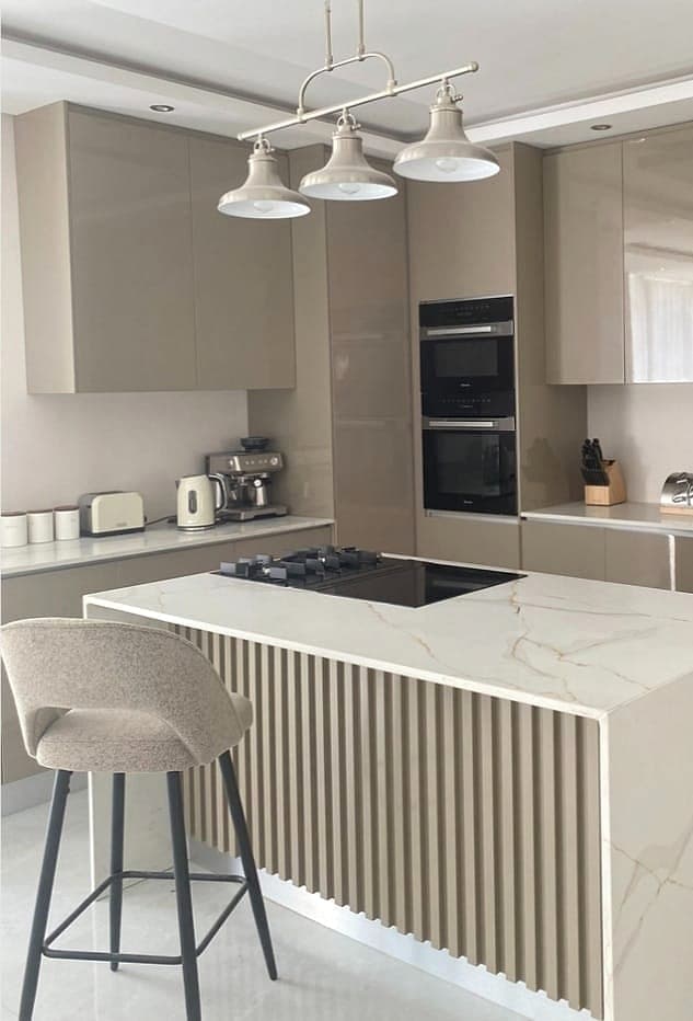 A fluted taupe kitchen island with custom cabinetry by MicWood Furnitures