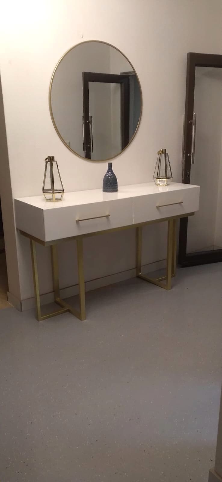 A console table with brass legs and round mirror